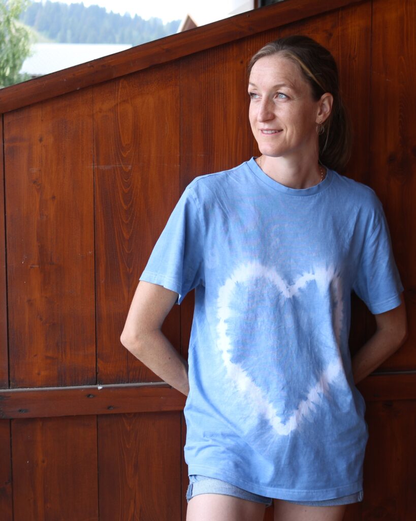 Lucile, créatrice de Lulafé, portant un tee-shirt coeur en shibori coloré à la teinture végétale par ses soins à Grenoble grâce à sa cuve à indigo au fructose